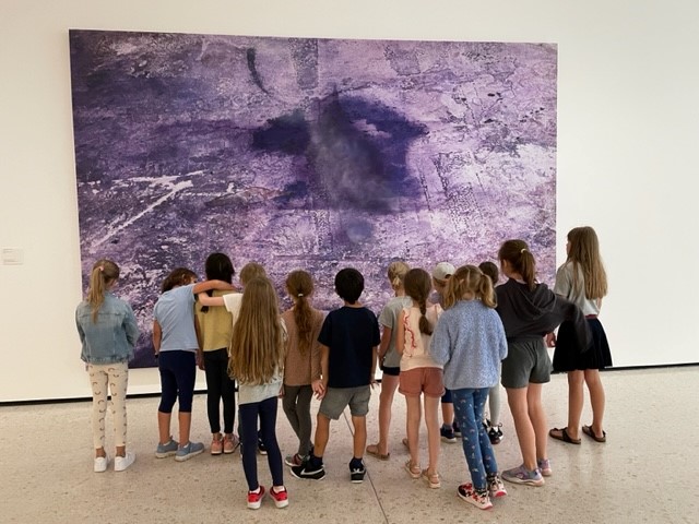 Kinder stehen vor einem Gemälde im Museum